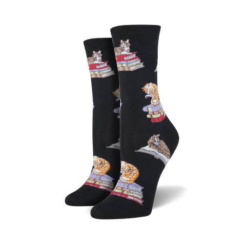 Pair of black crew socks with a repeating pattern of cats sitting on stacks of books.  Cats are orange and grey.