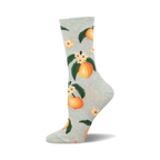 A pair of light green crew socks adorned with a repeating pattern of ripe peaches, green leaves, and delicate white flowers.