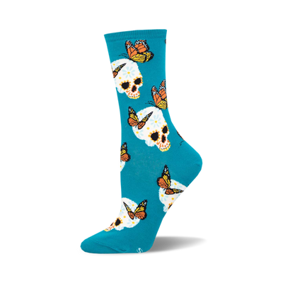 the blue socks have an all-over pattern of white skulls with pink, yellow, and orange flowers on them. there are also monarch butterflies in various positions around the skulls.