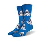 Pair of crew socks in blue featuring a repeating pattern of great white shark faces breaking the water's surface.