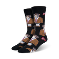 A pair of black crew socks with a repeating pattern of monkeys wearing brown suits and red ties.  Small red lips are also part of the design.