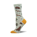 Crew socks in light green with a desert theme.  Features cacti, a tortoise, a snake, a javelina, and other desert animals. Yellow heel and toe.