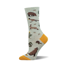 the green sock has a pattern of desert animals and plants. there are snakes, rabbits, tortoises, javelinas, and cacti.