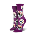 A pair of women's crew socks in purple with a fun pattern of colorful sugar skulls. Perfect for Dia de los Muertos!