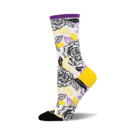 socks that are white with a pattern of black and yellow roses and green leaves. the toes and heels of socks that are black and the tops are purple.