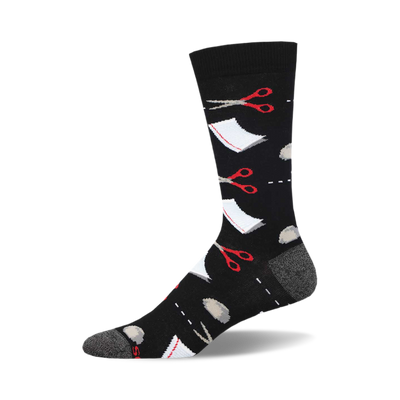 socks that are black and have a pattern of red scissors and grey rocks scattered all over. there is also a white square with a dotted line around it to represent paper.