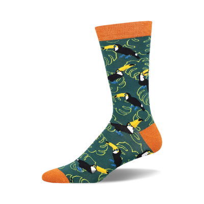 socks with a pattern of toucans, leaves, and bamboo. the toucans are black, yellow, and blue with orange feet and they are standing on branches of bamboo. the leaves are green with yellow and orange veins. the background is dark green.