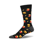 A single black crew sock with a fun pixelated design of burgers and french fries in red and yellow.  Gray reinforced heel and toe.