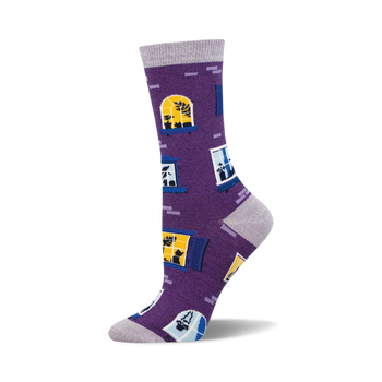 the window cats bamboo socks are purple with a pattern of blue and yellow windows. the windows have cats in them.