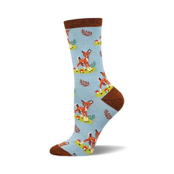 socks that are light blue with a pattern of deer, mushrooms, and leaves. the deer are brown with white spots. the mushrooms are red with white spots. the leaves are green. }}
