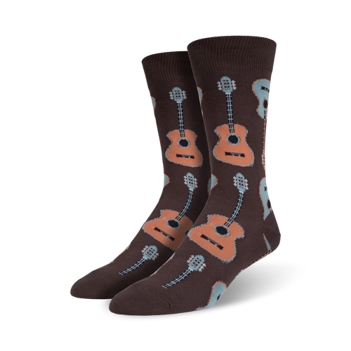 Lifestyle shot: Model wearing brown crew socks with a pattern of light brown and blue guitars.