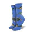 A pair of women's crew socks in blue, featuring a pattern of sea turtles swimming amongst bubbles. The turtles are green, brown, and beige.