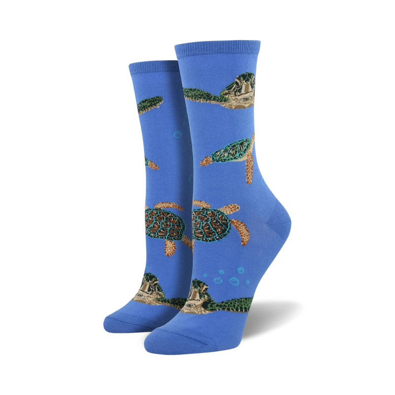 A pair of women's crew socks in blue, featuring a pattern of sea turtles swimming amongst bubbles. The turtles are green, brown, and beige.