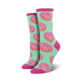 A pair of women's crew socks with a mint green background and a repeating pattern of pink donuts with colorful sprinkles.
