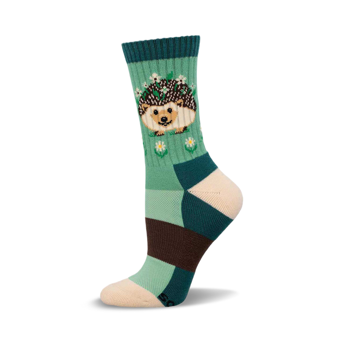 a green, teal, brown, and cream sock with a hedgehog wearing a flower crown on it. }}