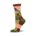 Close-up of a woman's crew sock. The sock features a colorful patchwork design in muted greens, browns, and peach, and an illustration of a quail among poppies.
