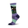 Crew socks in purple, green, and dark blue featuring a moose illustration in a lakeside scene.