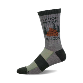 a grey sock with black and green stripes. it has the words "i poop in the woods" and a cartoon image of poop in the woods on it.