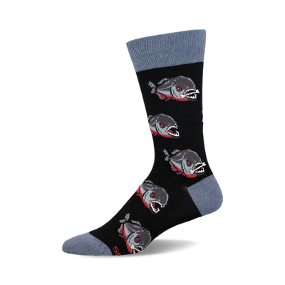 a black sock with a blue cuff. the sock has a pattern of grey and red fish with sharp teeth.