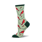 Side view of a crew sock featuring red cardinals and green branches on a light green background. The sock has a dark green heel and toe.