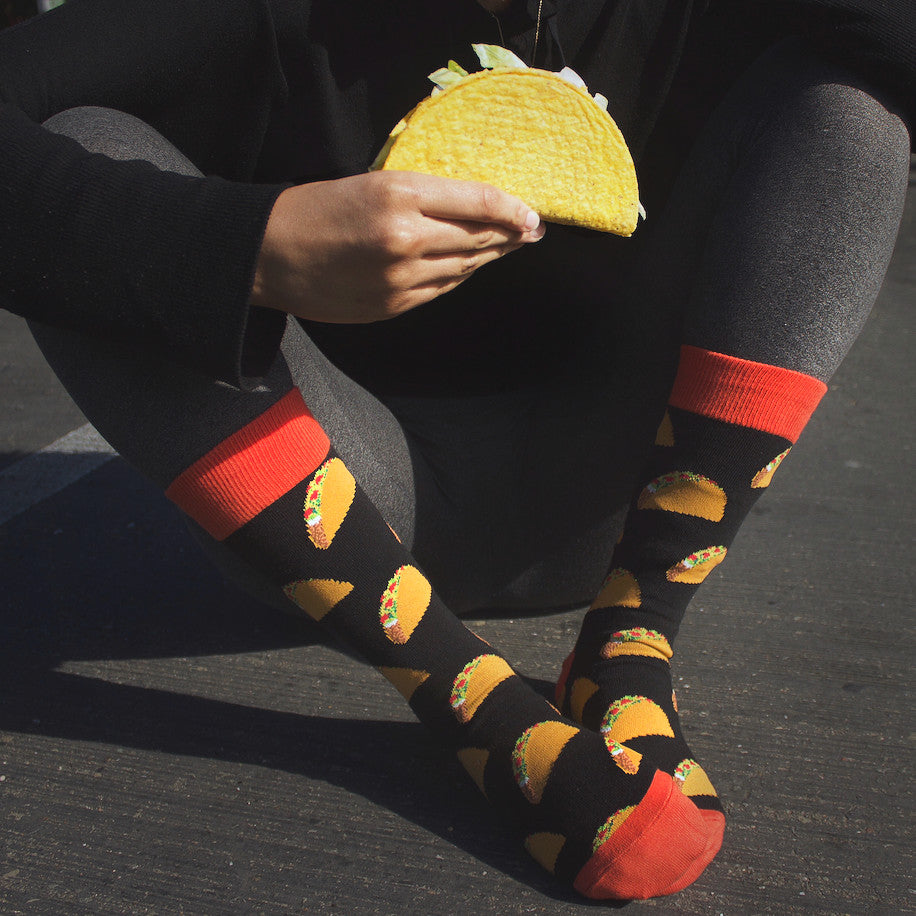 Lifestyle photo: Person wearing the taco socks and holding a real taco. [lf]