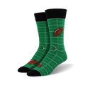 Pair of green crew socks with a football field design and brown football graphics. Black cuff.