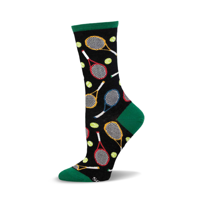 a black sock with a green cuff. the sock has a pattern of tennis rackets and tennis balls. }}