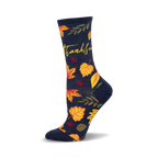 Crew socks in navy blue with yellow, orange, and red autumn leaves and the word 'Thankful' in yellow script.