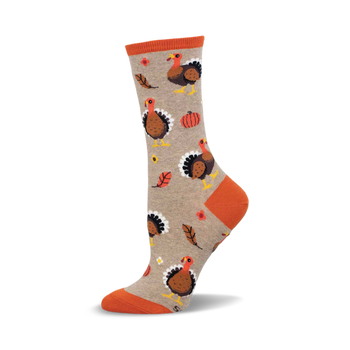 a tan sock with an orange top and a pattern of turkeys, leaves, and pumpkins.