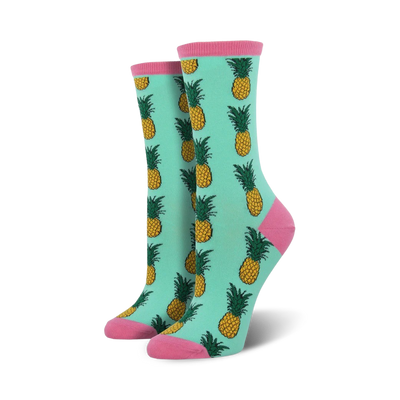 mint green socks featuring a pattern of yellow pineapples with green leaves and pink toes and heels.    