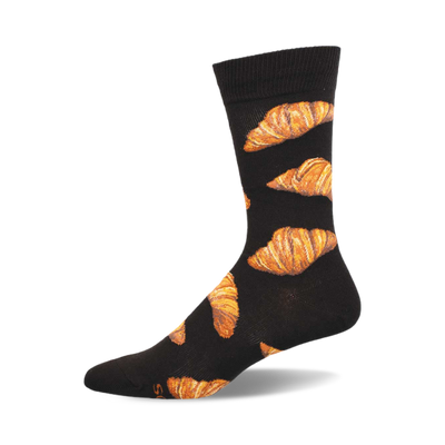 side view of flaky croissant socks. black socks with a pattern of golden brown croissants.