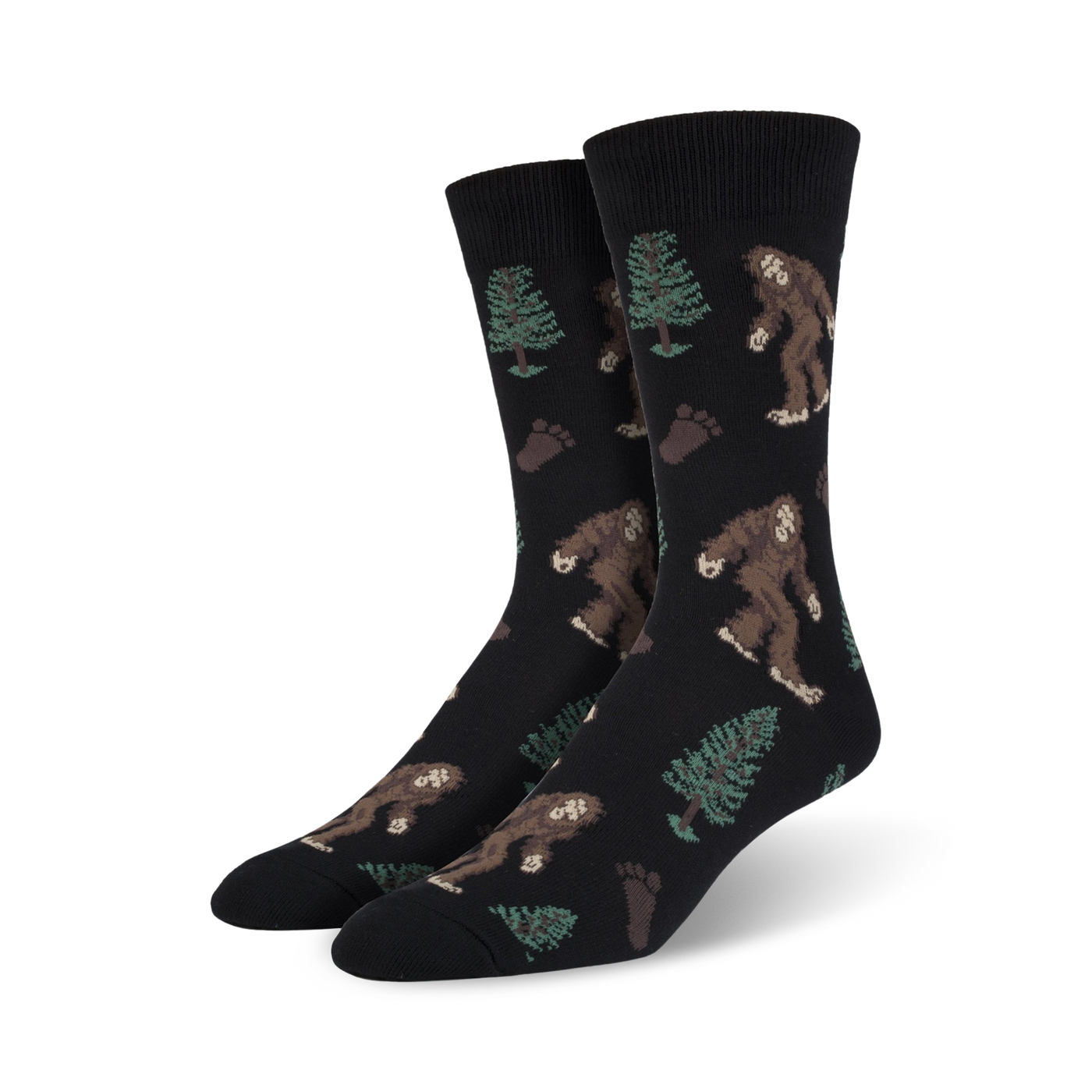 Pair of black Bigfoot XL crew socks. Features repeating pattern of Bigfoot, trees, and footprints. Brown, green, and black design on a black background.