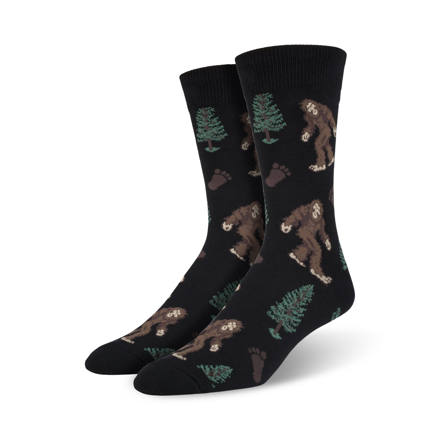 Pair of black Bigfoot XL crew socks. Features repeating pattern of Bigfoot, trees, and footprints. Brown, green, and black design on a black background.