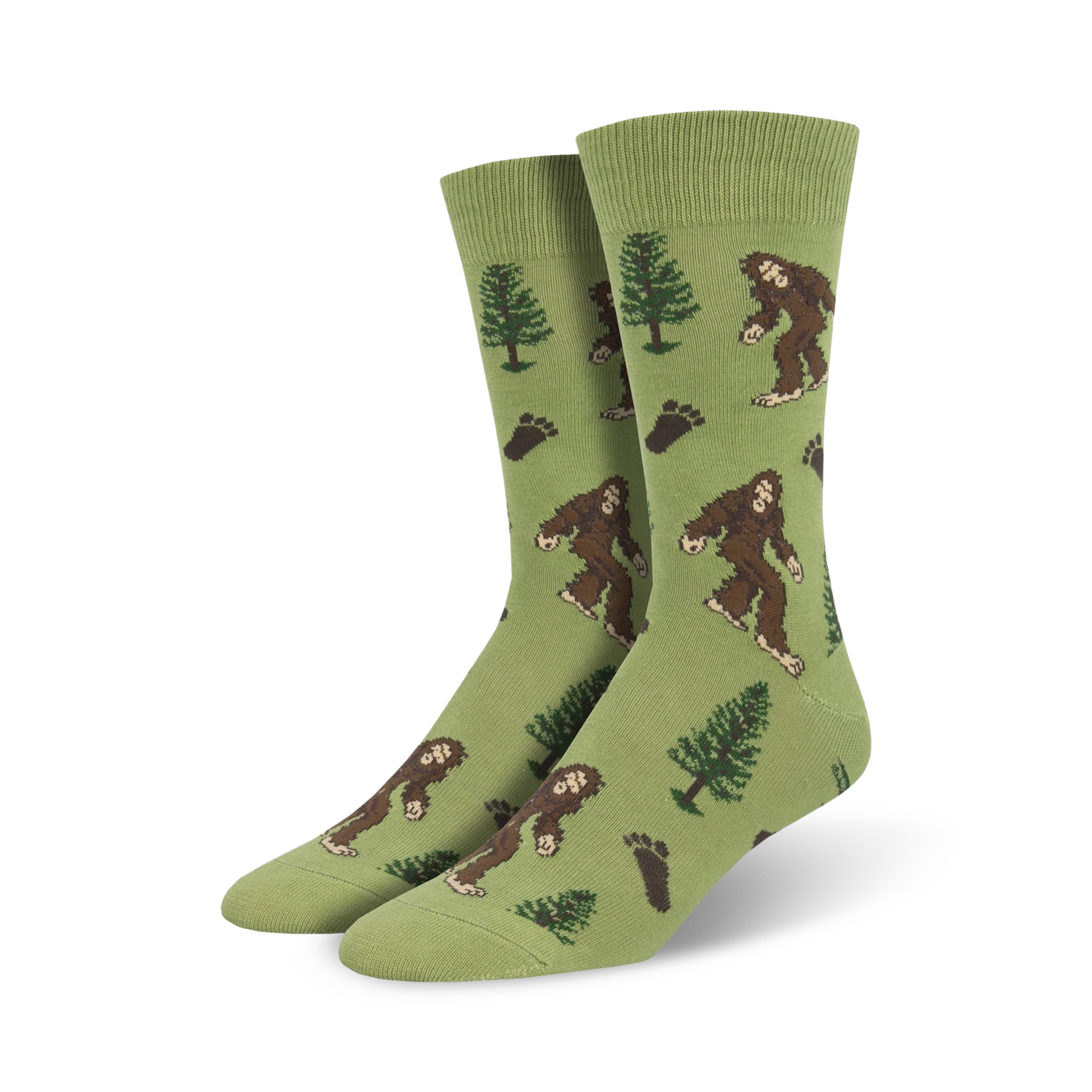 Lifestyle shot of a person's feet wearing a pair of olive green Bigfoot XL crew socks.  The socks feature a pattern of Bigfoot, trees, and footprints.
