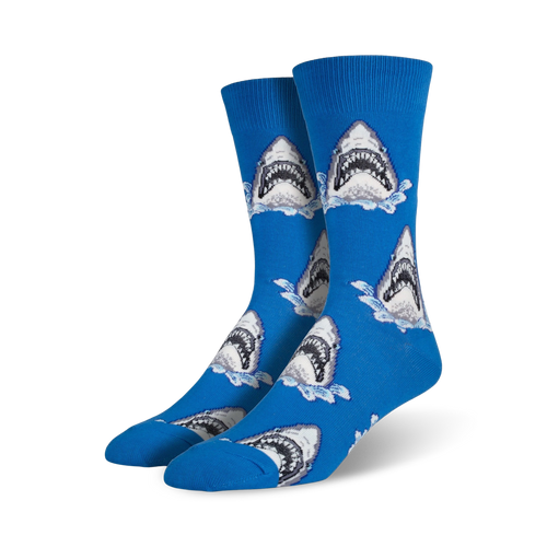 A pair of men's blue crew socks with a repeating pattern of great white shark jaws breaking the water's surface. 