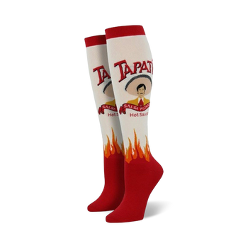  white knee-high socks for women feature red flames at the bottom and a tapatio hot sauce bottle graphic on the front with a sombrero-wearing man. 