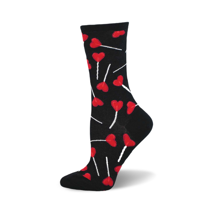 side view of black crew socks featuring a pattern of red heart-shaped lollipops.  