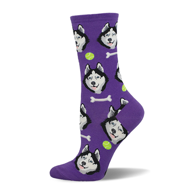 Purple crew sock with an all-over pattern of black and white husky dog faces, white bones, and lime green tennis balls.