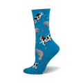 Crew socks in bright blue with a whimsical design of black and white cows and gray manatees swimming amongst orange fish.