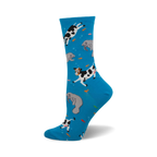 Crew socks in bright blue with a whimsical design of black and white cows and gray manatees swimming amongst orange fish.