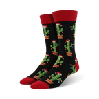Pair of crew socks; black background with repeating pattern of cacti wearing Santa hats and Christmas lights; red cuffs.