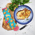 Lifestyle product shot of a single teal grilled cheese sock next to an actual grilled cheese sandwich on a plate. [lf]