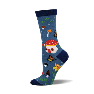 Crew socks in blue featuring mushrooms, butterflies, daffodils, and a mushroom house.  A whimsical nature-inspired design.