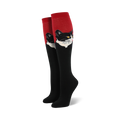 Close-up view of a pair of red and black knee-high socks with a black and white cat portrait.