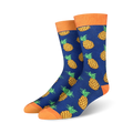 A pair of blue crew socks with a repeating pattern of yellow pineapples.  The socks have orange cuffs.