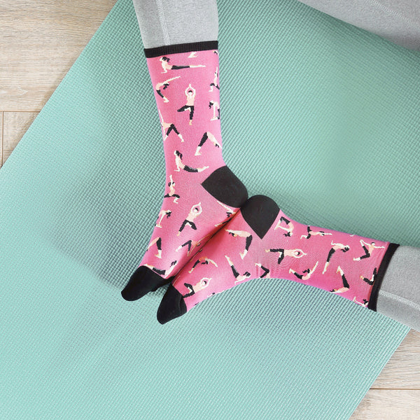 Flatlay product shot of pink yoga socks on a teal yoga mat. [lf]