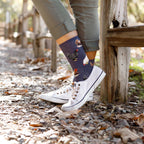 Lifestyle shot of woman's legs wearing the navy blue chicken socks with white canvas shoes. [lf]