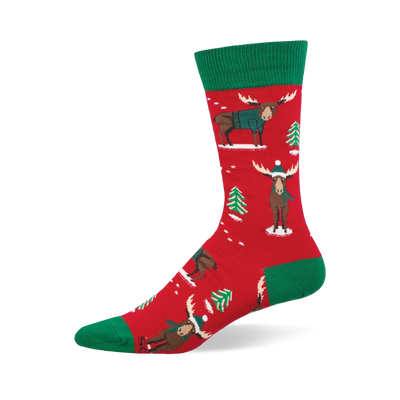 Red crew socks with green accents, featuring festive moose in teal sweaters and beanies, plus green Christmas trees and white snow.