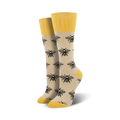 Pair of beige crew socks with black bee illustrations and yellow cuffs.
