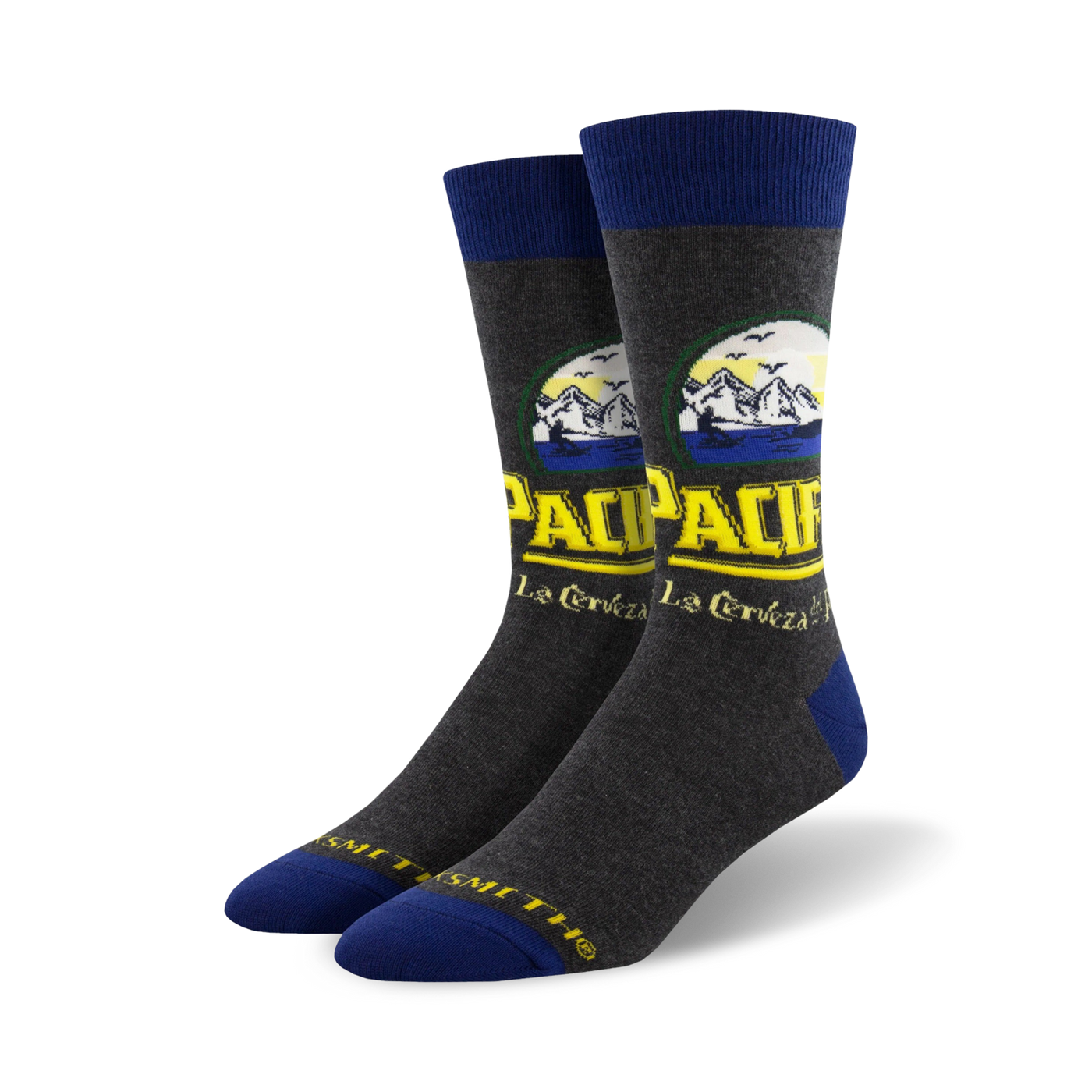 Pair of crew socks in grey with a Pacifico beer-inspired design featuring yellow and blue text and mountain imagery.